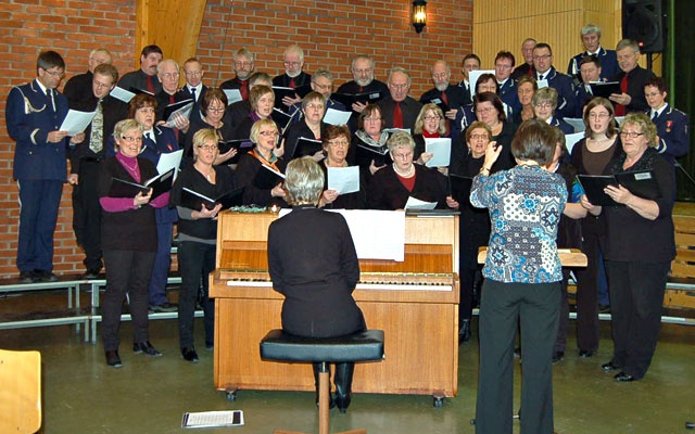 Meldal songlag og medlemmer av Løkken Musikkorps i felles opptreden. Dirigent Hilde Bøgh og på piano Gretha Loe.  