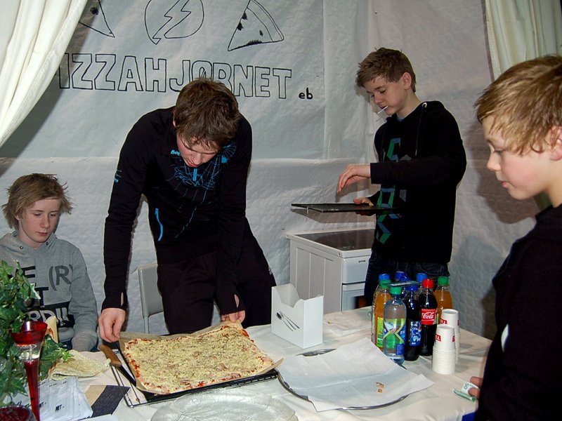 Pizzaen klargjøres for steking 