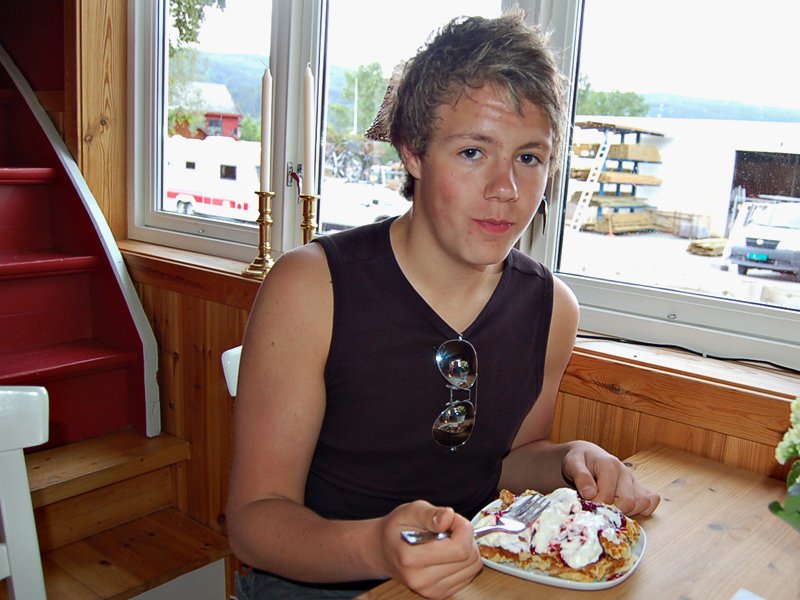 Christian Rindal spiser rotvaffel (deler den i biter) med rømme og syltetøy. Kakao med krem er tilbehør, -han syns de bli best med kakao attåt!  